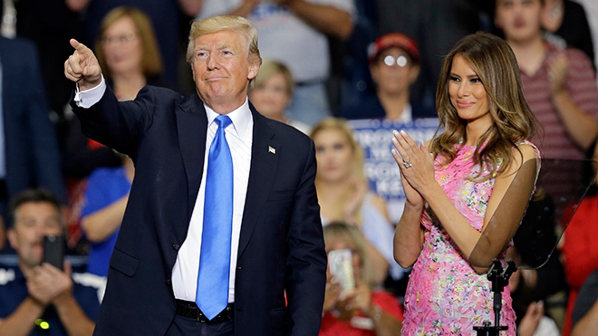 President Donald Trump points to his supporters as first lady Melania Trump watches after speaking at the Covelli Centre, Tuesday, July 25, 2017, in Youngstown, Ohio. (AP Photo/Tony Dejak)
