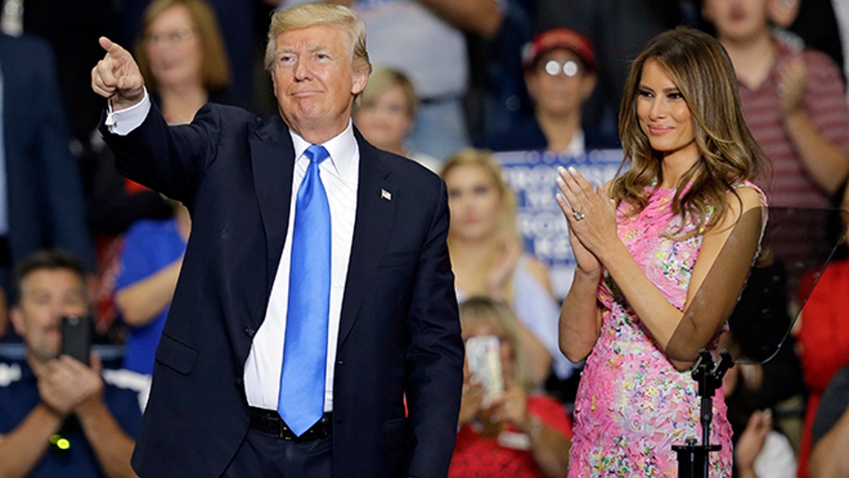 President Donald Trump points to his supporters as first lady Melania Trump watches after speaking at the Covelli Centre, Tuesday, July 25, 2017, in Youngstown, Ohio. (AP Photo/Tony Dejak)