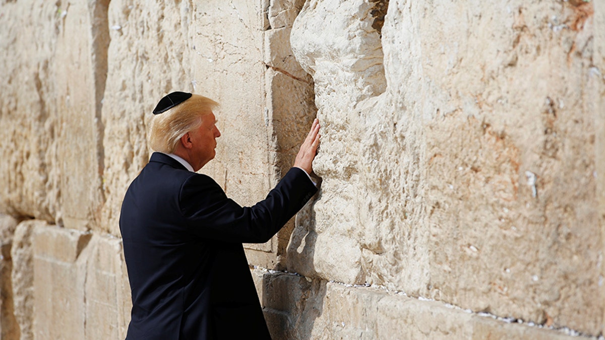 U.S. President Donald Trump touches the Western Wall, Judaism's holiest prayer site, in Jerusalem's Old City May 22, 2017. REUTERS/Ronen Zvulun - RC135F8F7620