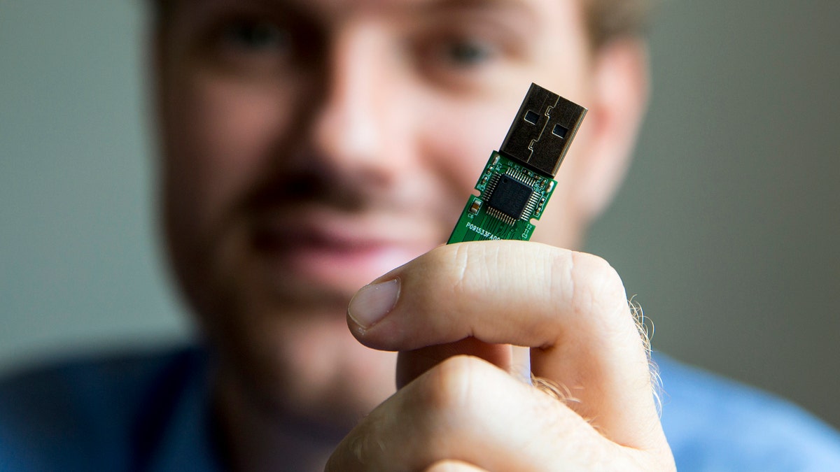 German crypto specialist and chief scientist with Berlin's SR Labs Karsten Nohl poses with a USB stick at his office in Berlin, July 30, 2014. USB devices such as mice, keyboards and thumb-drives can be used to hack into personal computers in a potential new class of attacks that evade all known security protections, Nohl revealed on Thursday. Picture taken July 30, 2014.  REUTERS/Thomas Peter (GERMANY - Tags: SCIENCE TECHNOLOGY CRIME) - GM1EA7V0OZD01