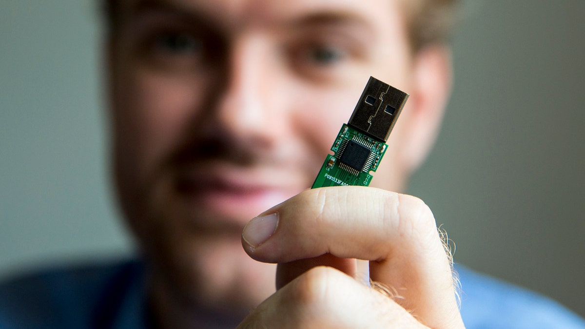 German crypto specialist and chief scientist with Berlin's SR Labs Karsten Nohl poses with a USB stick at his office in Berlin, July 30, 2014. USB devices such as mice, keyboards and thumb-drives can be used to hack into personal computers in a potential new class of attacks that evade all known security protections, Nohl revealed on Thursday. Picture taken July 30, 2014.  REUTERS/Thomas Peter (GERMANY - Tags: SCIENCE TECHNOLOGY CRIME) - GM1EA7V0OZD01