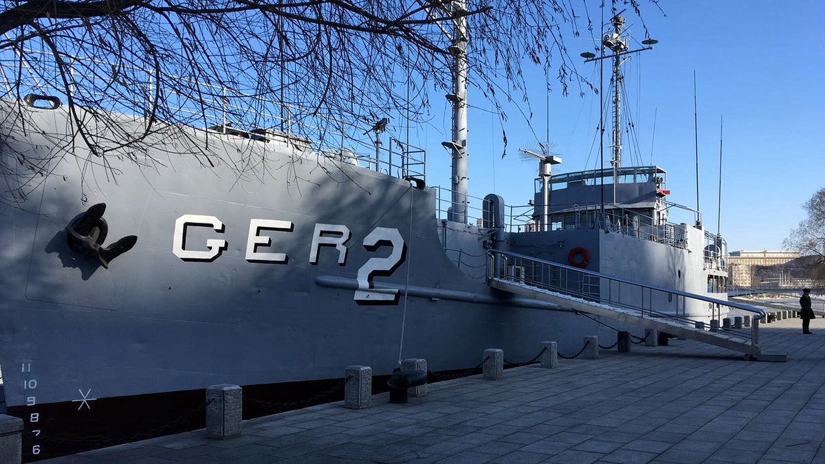 In this Wednesday, Jan. 24, 2018, photo, a North Korean military security guard keeps watch over the USS Pueblo in Pyongyang, North Korea. The Pueblo, an American spy ship, was attacked and captured by North Korea 50 years ago this week. The iconic spy ship, on display in Pyongyang, is the only commissioned US Navy ship held by a foreign government. (AP Photo/Eric Talmadge)