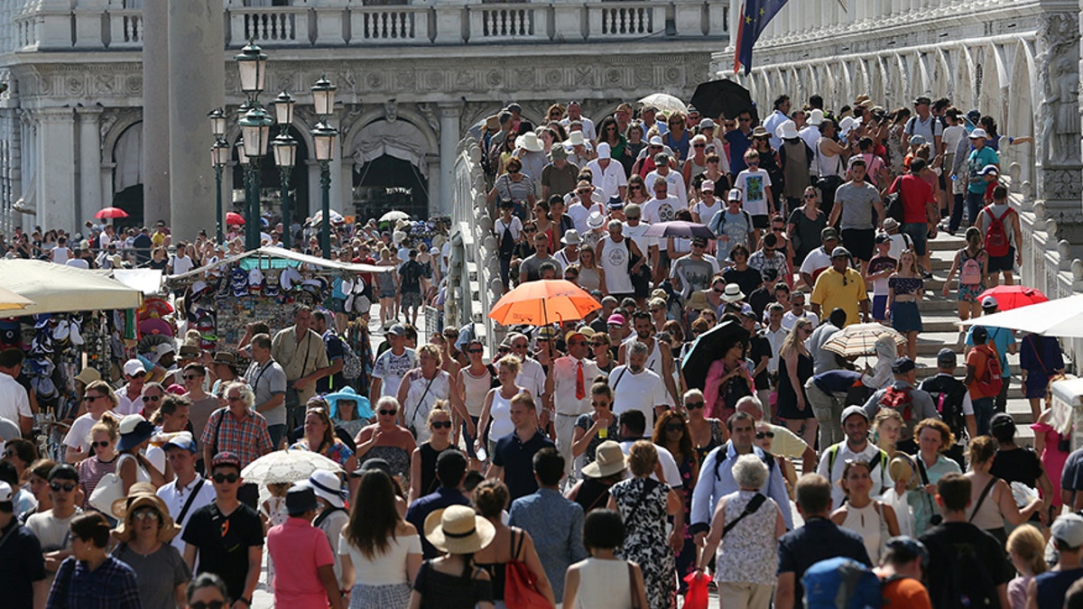 Tourists walk near St. Mark's Square in Venice, Italy, August 3, 2017. REUTERS/Stefano Rellandini - RTS1A9T8