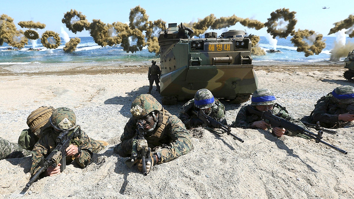 Marines of the U.S., left, and South Korea wearing blue headbands on their helmets