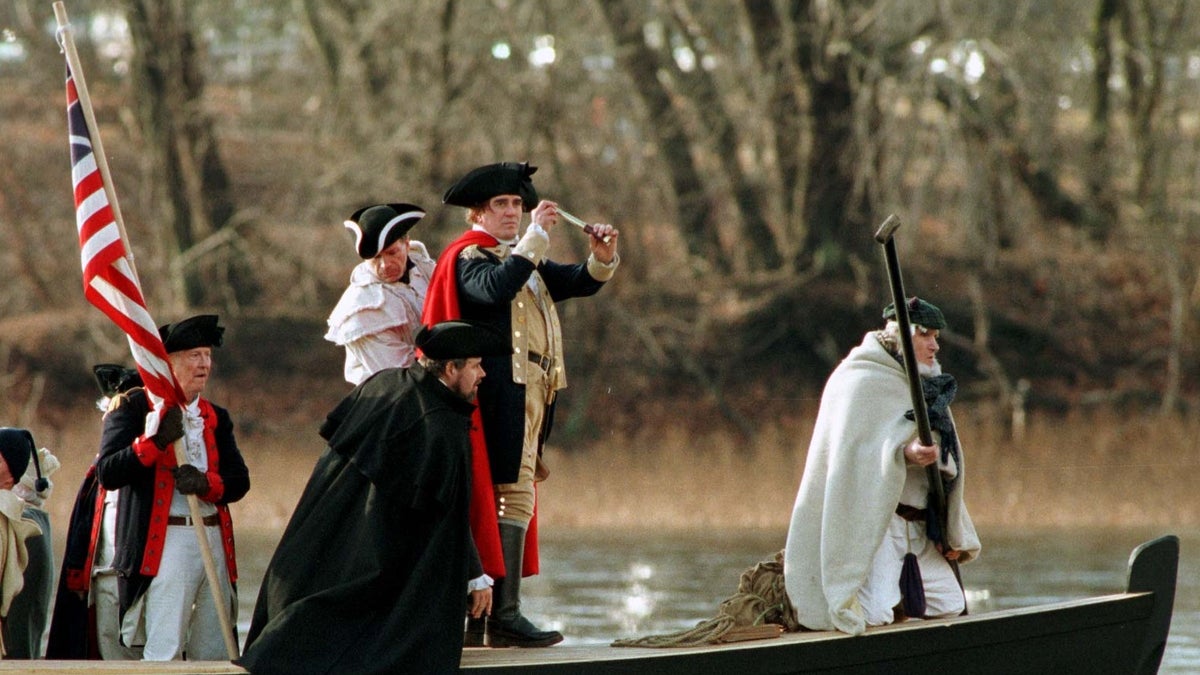 General George Washington, portrayed by Bob Gerenser, 43, of New Hope, Pennsylvania, (second from right) crosses the Delaware River with his troops to Trenton, New Jersey, from the Washington Crossing Historic Park in Pennsylvania, December 25. This year's reenactment marks the 221st anniversary of the crossing which led to the victory at Trenton during the Revolutionary War. By crossing the ice-filled Delaware River on Christmas night, 1776, Washington led a surprise attack on the Hessian Troops in Trenton and changed the course of events in the war. blj/Photo by Barbara L. WASHINGTON - RP1DRIDFDFAC