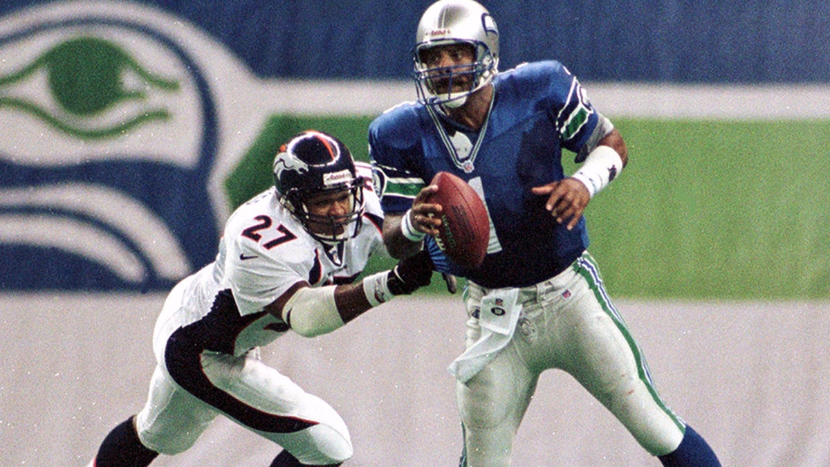 Seattle Seahawks starting quarterback Warren Moon (R) scrambles away from Denver Broncos safety Steve Atwater during the third quarter October 11. Moon, who played with a cracked rib, threw an incomplete pass during the play. The Broncos won 23-16.

APB/RC/FMS - RP1DRIGUIYAB