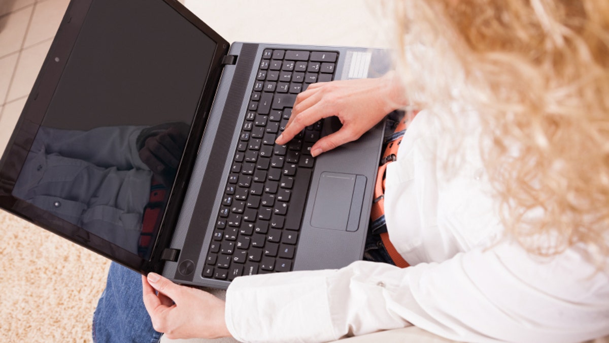 Young woman with laptop in living room