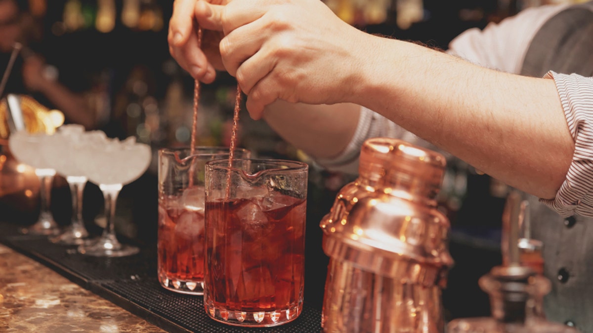 707a0346-Bartender is stirring cocktails