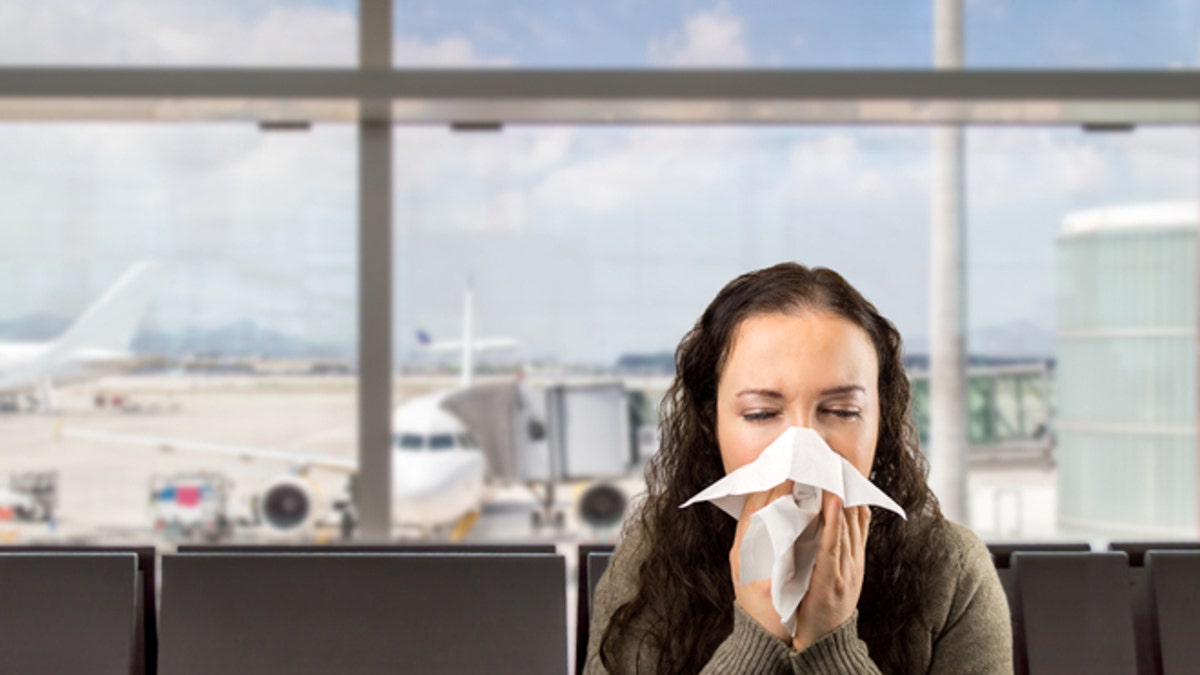 sick woman sneezing at the  airport