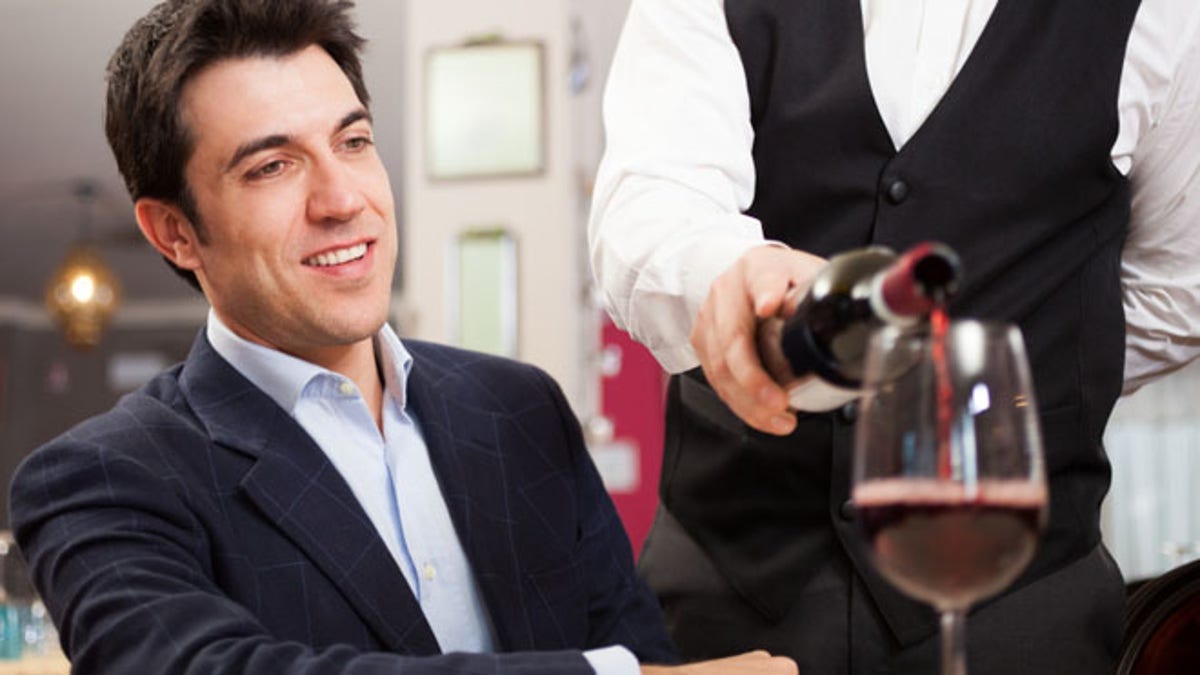 Waiter pouring wine