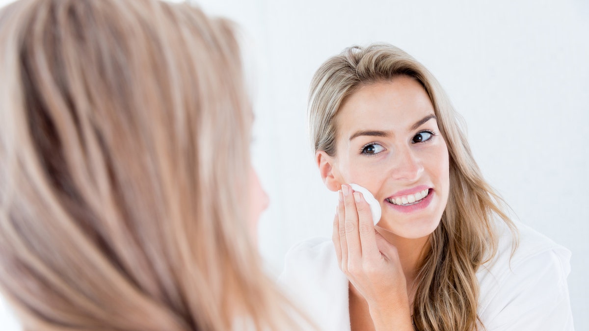 woman cleaning her face age spots makeup acne washing face istock medium