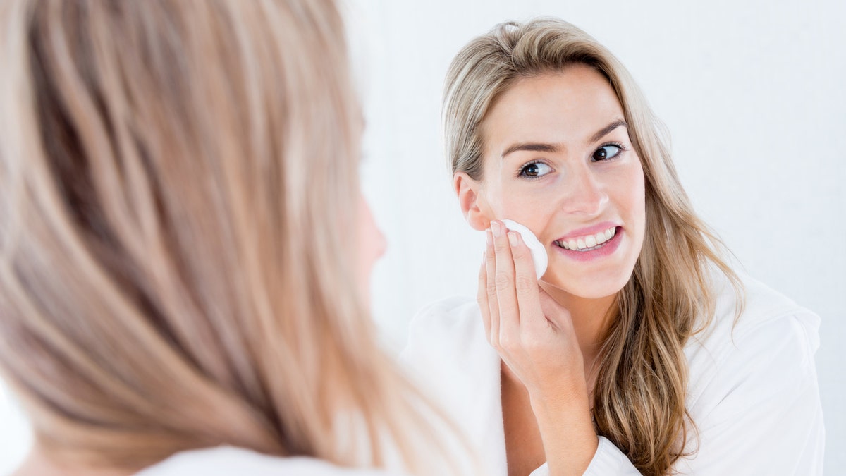 woman cleaning her face age spots makeup acne washing face istock medium