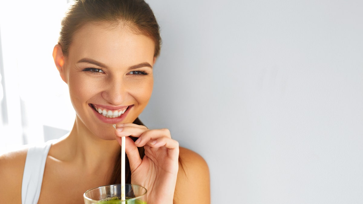 woman drinking green juice istock medium