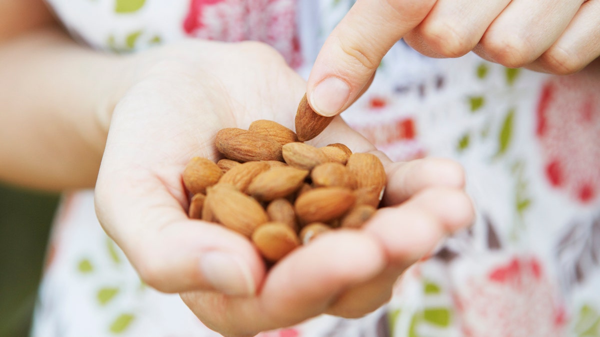 Woman holds handful of almonds