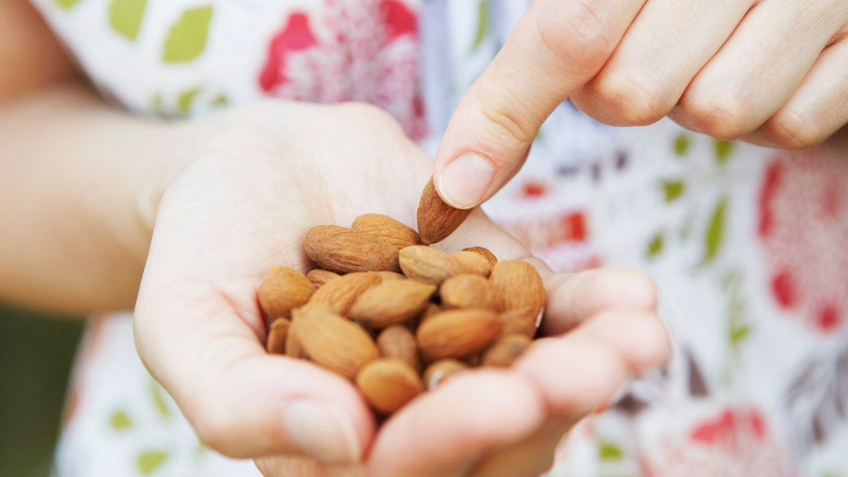 woman eating almonds istock medium