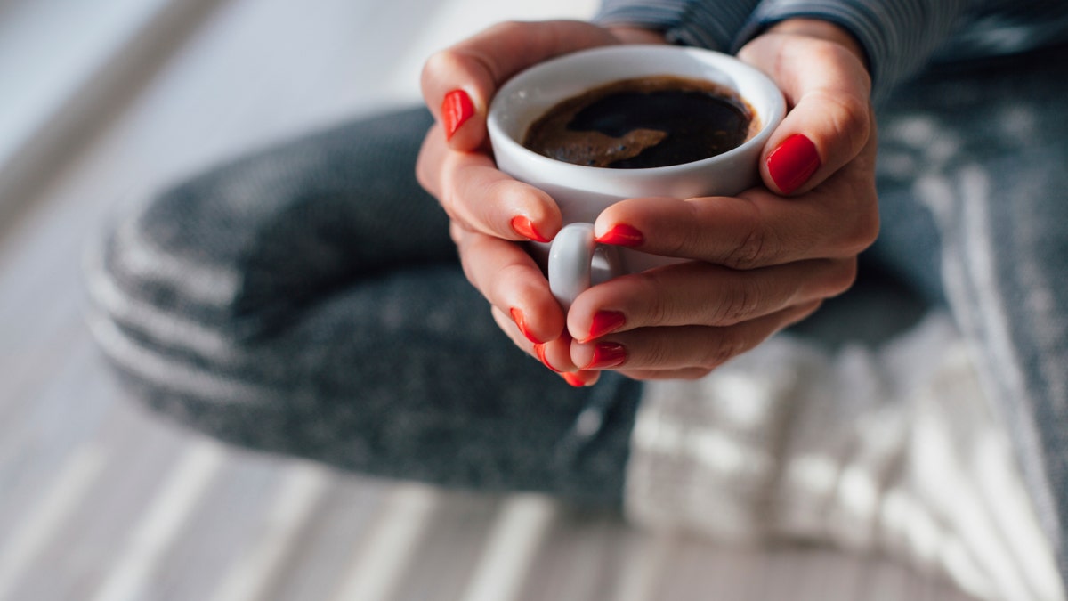 woman holding cup of coffee