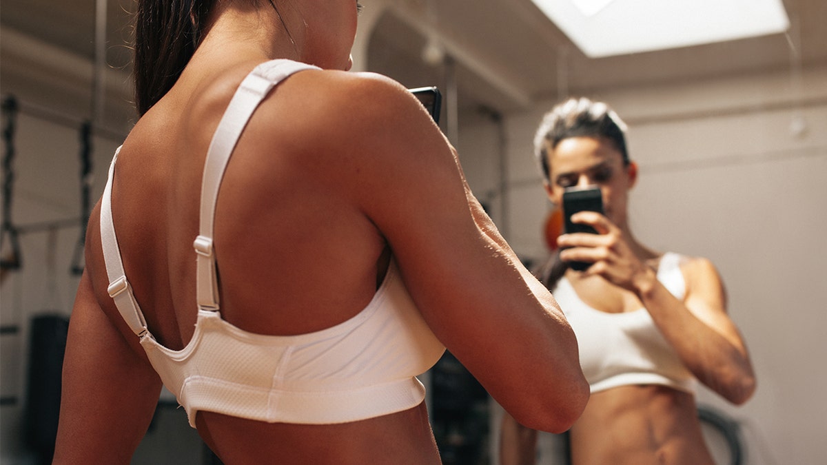 woman taking pic in gym istock