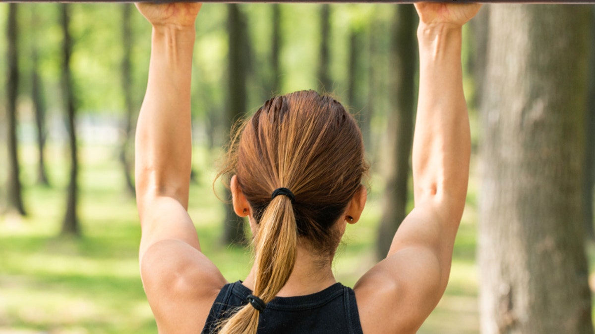 Back view of female doing pull ups