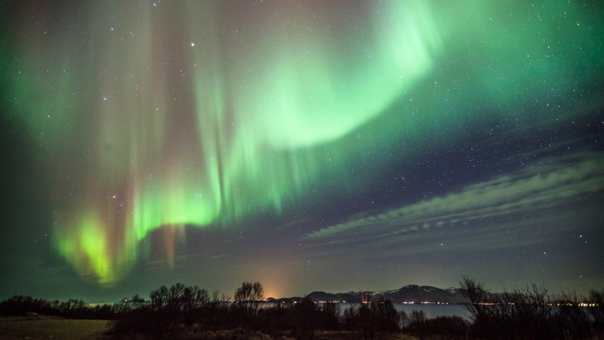 horiziontal composition of aurora borealis over the sea