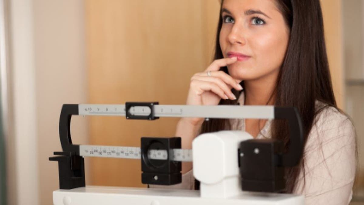 young woman on scale istock