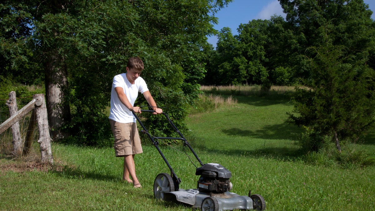 youngster mowing the lawn istock large