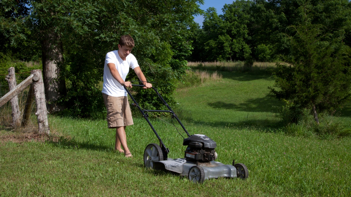 youngster mowing the lawn istock large