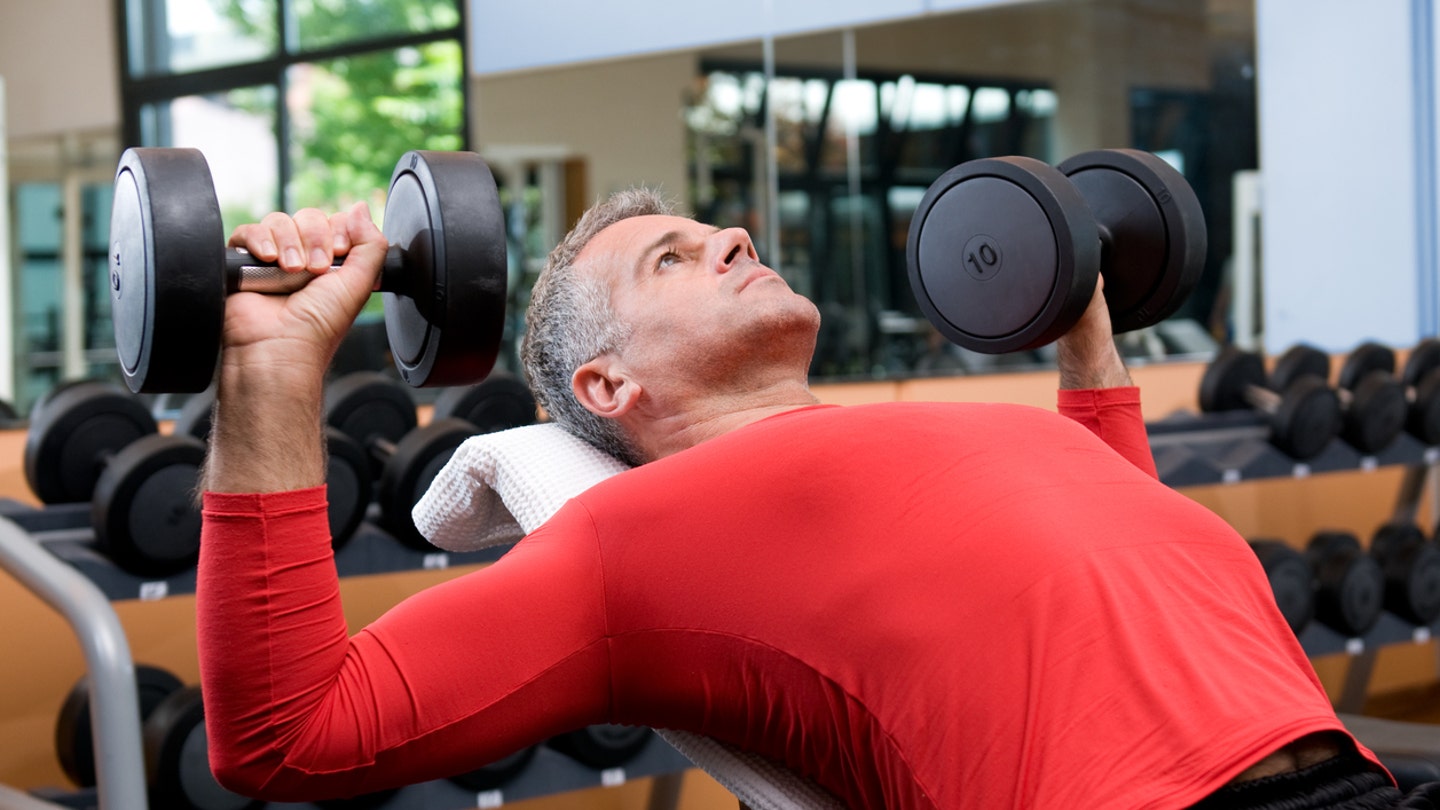 middle age man lifting weights strength training dumbbells istock medium