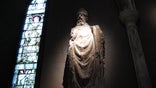This January 2, 2014 photo shows a statue of St. Patrick in St. Patrick's Cathedral, Dublin. The  stained glass window depicts the life of the fifth-century saint who brought Christianity to Ireland. (AP Photo/Helen ONeill)