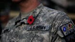 An American soldier wears a poppy emblem stuck to his uniform during a ceremony marking Veterans Day at the U.S. Camp Eggers in Kabul, Afghanistan, Wednesday, Nov. 11, 2009. (AP Photo/Anja Niedringhaus)