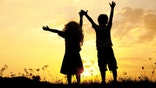 Silhouette, group of happy children playing on meadow, sunset, summertime