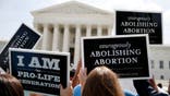 Anti-abortion protestors celebrate the U.S. Supreme Court's ruling striking down a Massachusetts law that mandated a protective buffer zone around abortion clinics,  outside the Court in Washington June 26, 2014. On a 9-0 vote, the court said the 2007 law violated the freedom of speech rights of anti-abortion protesters under the First Amendment of the U.S. Constitution in preventing them from standing on the sidewalk and speaking to people entering the clinics. REUTERS/Jim Bourg  (UNITED STATES - Tags: POLITICS CRIME LAW HEALTH CIVIL UNREST) - WASEA6Q0W2A01