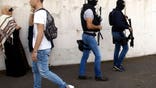 Members of the Research and Intervention Brigade (BRI) patrol after an attack in a high school in Grasse, southern France, Thursday, March 16, 2017. A French high school principal and two others were shot Thursday at their school in southern France, and a 17-year-old student suspected of opening fire on them was arrested in a police raid, officials said. (AP Photo/Philippe Farjon)