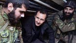 FILE - In this Wednesday, Dec. 31, 2014, file photo released by the Syrian official news agency SANA, Syrian President Bashar Assad, center, speaks with Syrian troops during his visit to the front line in the eastern Damascus district of Jobar, Syria. (AP Photo/SANA, File