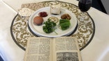 photo shows a 1936 Maxwell House Haggadah alongside a Seder plate in New York. The coffee maker's version of the Seder guide has been offered free at supermarkets with a Maxwell House purchase since the early 1930s. A major overhaul will be out this year in time for the holiday's start April 19. (AP Photo/Stace Maude)