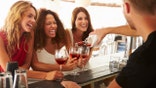 Three women share drinks with friends