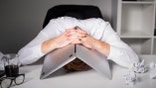 Man hiding under laptop