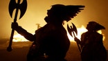 Men dressed as vikings stand in front of a 40 foot-long viking longship as it is burned on Calton Hill in Edinburgh.  Men dressed as vikings stand in front of a 40 foot-long (12 metres) viking longship as it is burned on Calton Hill in Edinburgh as the launch pad for the city's Hogmanay (New Year) celebrations December 29, 2004. The festival was attended by thousands of spectators and people dressed as vikings from Shetland. REUTERS/Jeff J Mitchell - RP5DRIDSVQAA
