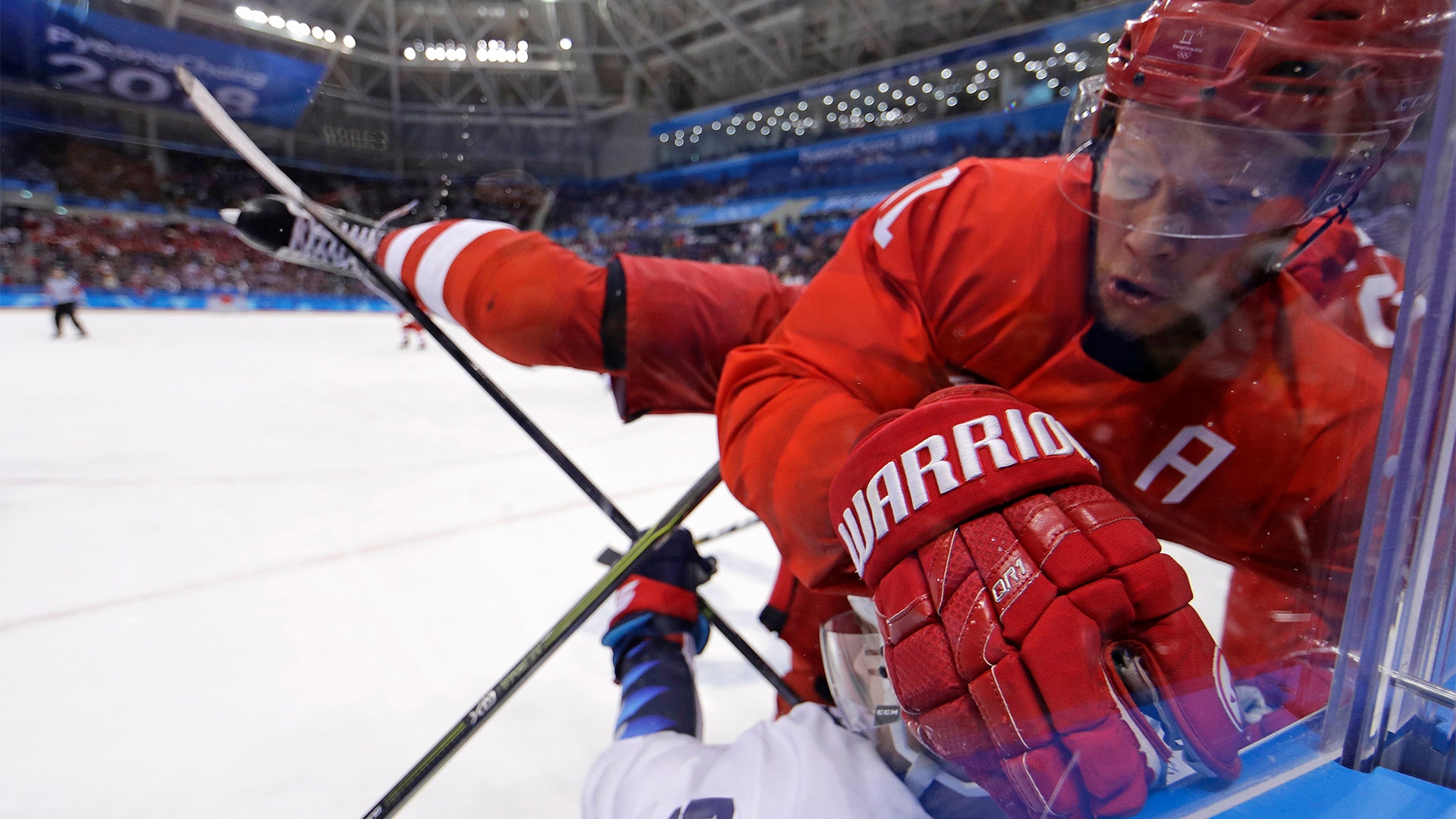 Russian Sergei Andronov (11) checks Noah Welch (5) during the second period of the preliminary round