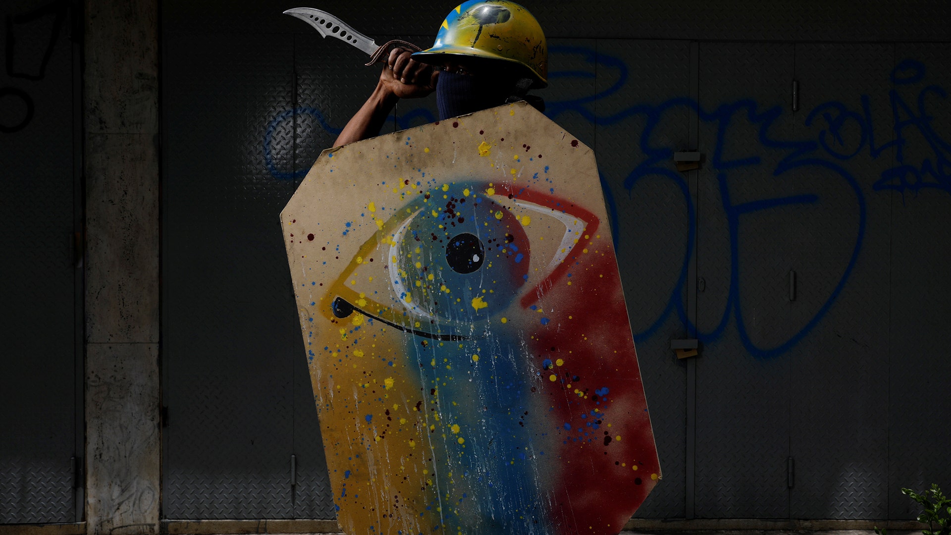 A demonstrator holding a rudimentary shield and a knife before a rally against Venezuelan President Nicolas Maduro's government in Caracas