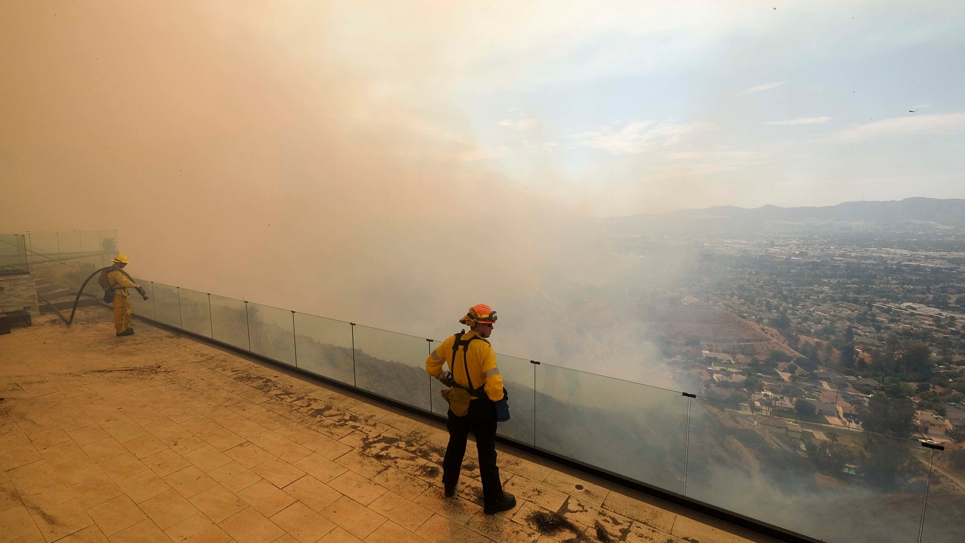 Fireflighters watch a brush fire burn on a hillside in Burbank, Calif., September 2