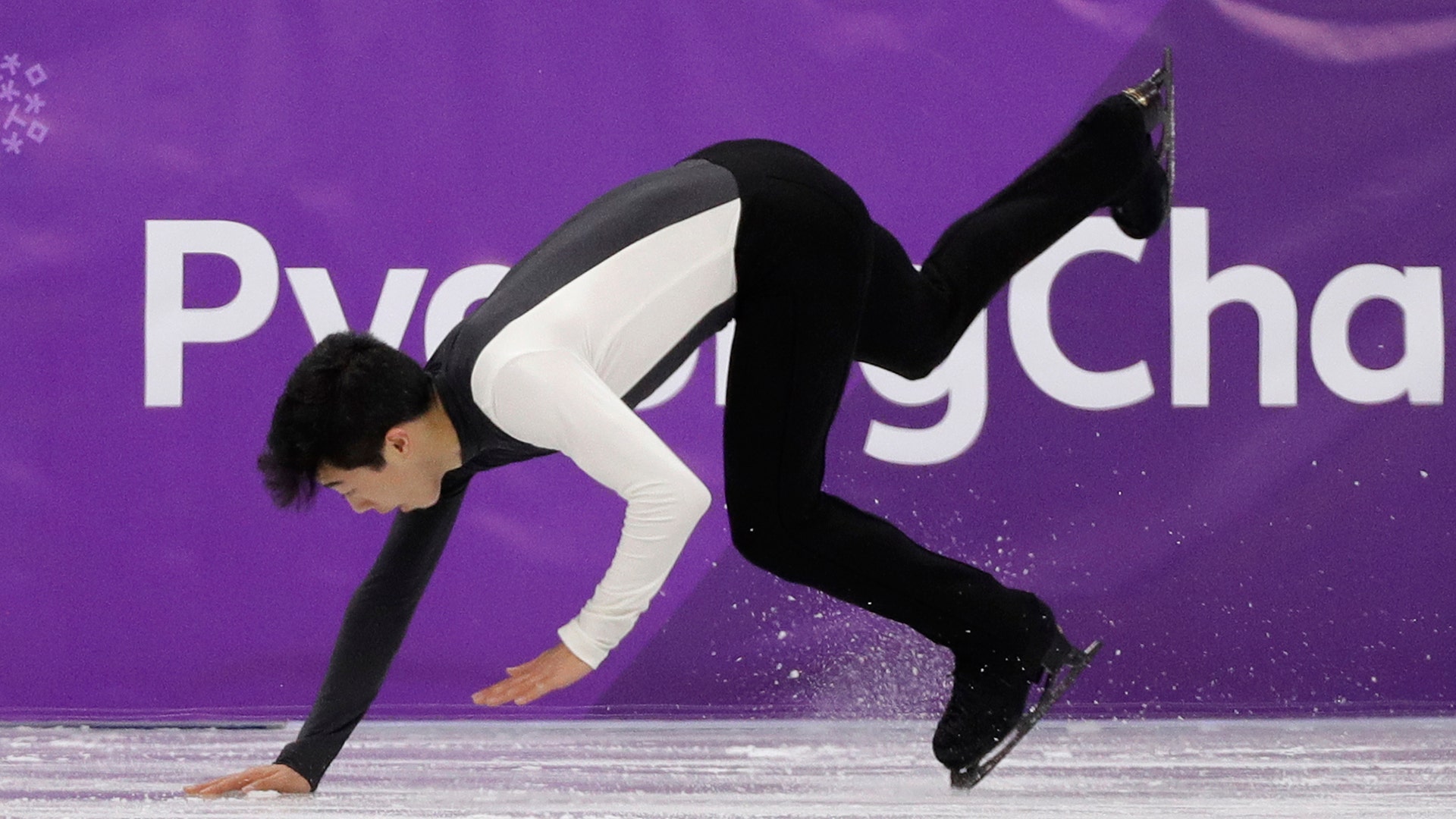 Nathan Chen of the United States falls while performing during the men's figure skating short program at the 2018 Winter Olympics