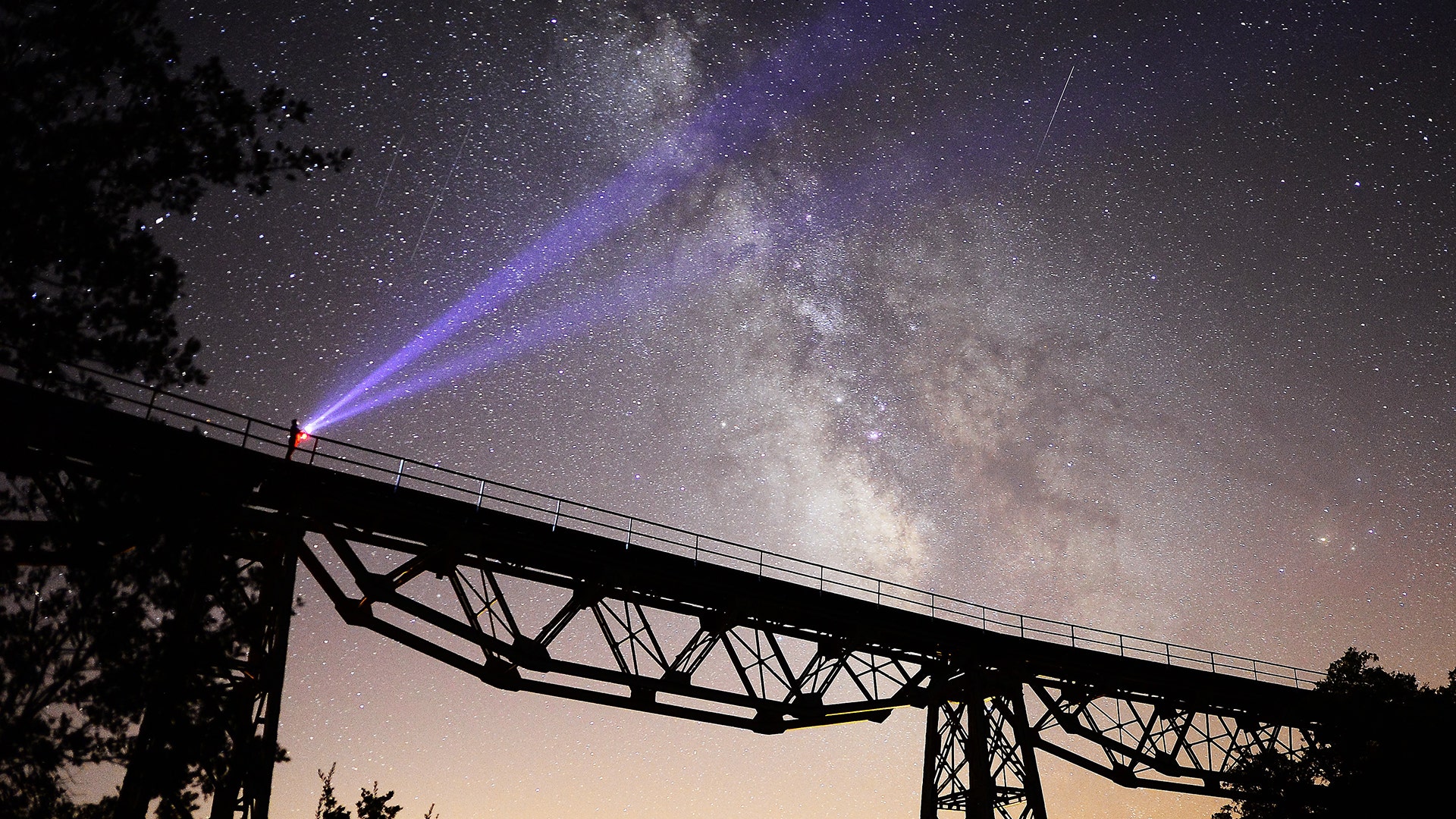 A person holds a flashlight up to night sky as Perseid meteors streak across the sky in Esme district of Usak, Turkey,  August 14, 2018