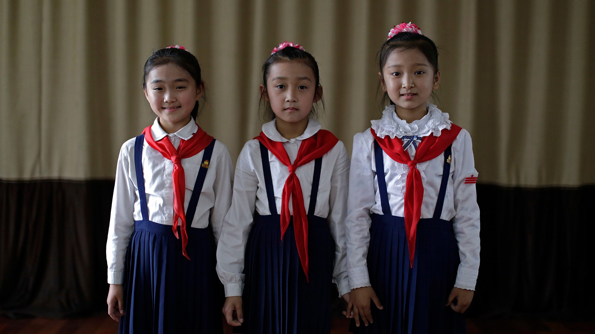 Sin Ji Ye, 9, An Rye Jong, 10, and Kim Ye Yon, 8 pose for a portrait as they attend a singing class in Pyongyang, North Korea, May 7, 2015