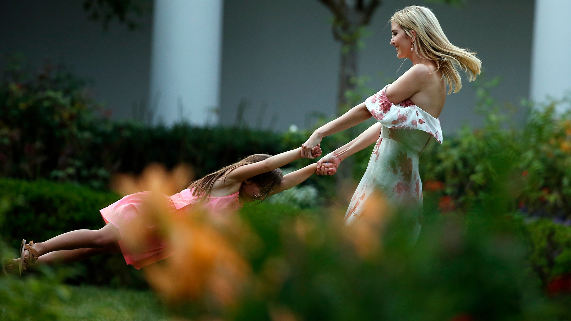 Ivanka Trump swings her daughter Arabella in the Rose Garden at the Congressional Picnic at the White House