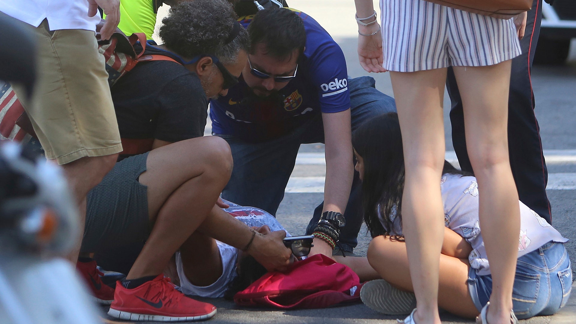 A person is treated after a van crashed into a crowd of residents and tourists on Las Ramblas in Barcelona, August 17