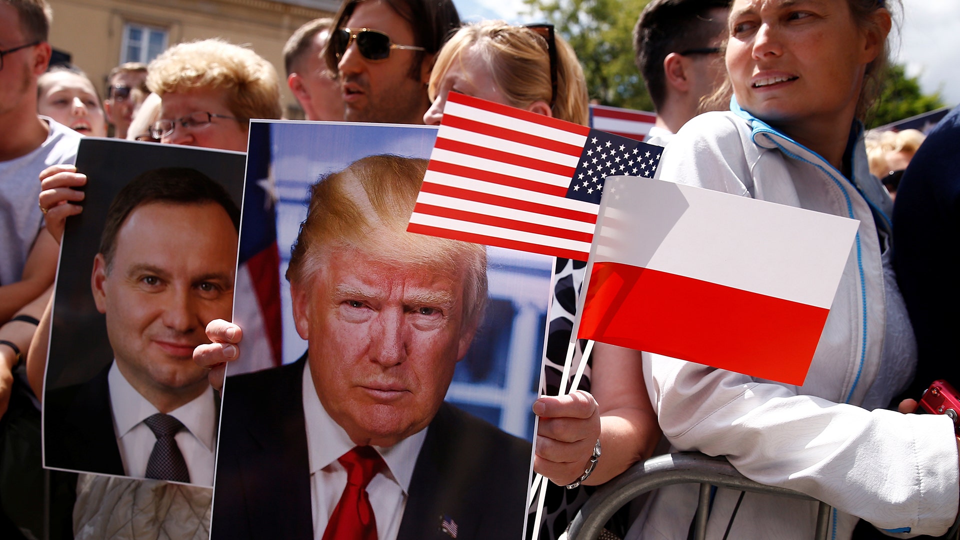 People hold a portrait of U.S. President Donald Trump during his public speech at Krasinski Square, in Warsaw, Poland