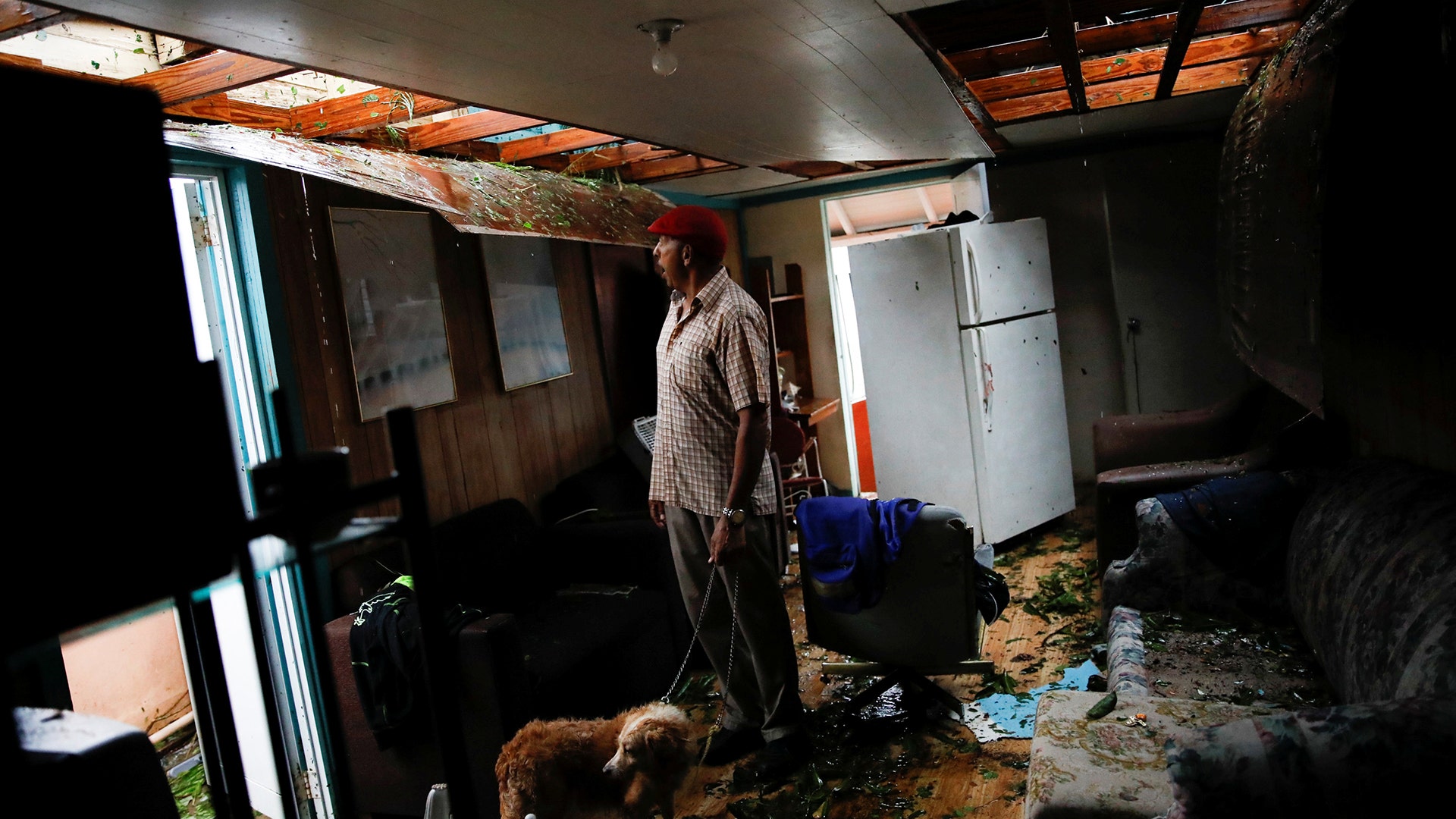 Agapito Lopez looks at the damage in his house after the area was hit by Hurricane Maria in Guayama, Puerto Rico, Wednesday
