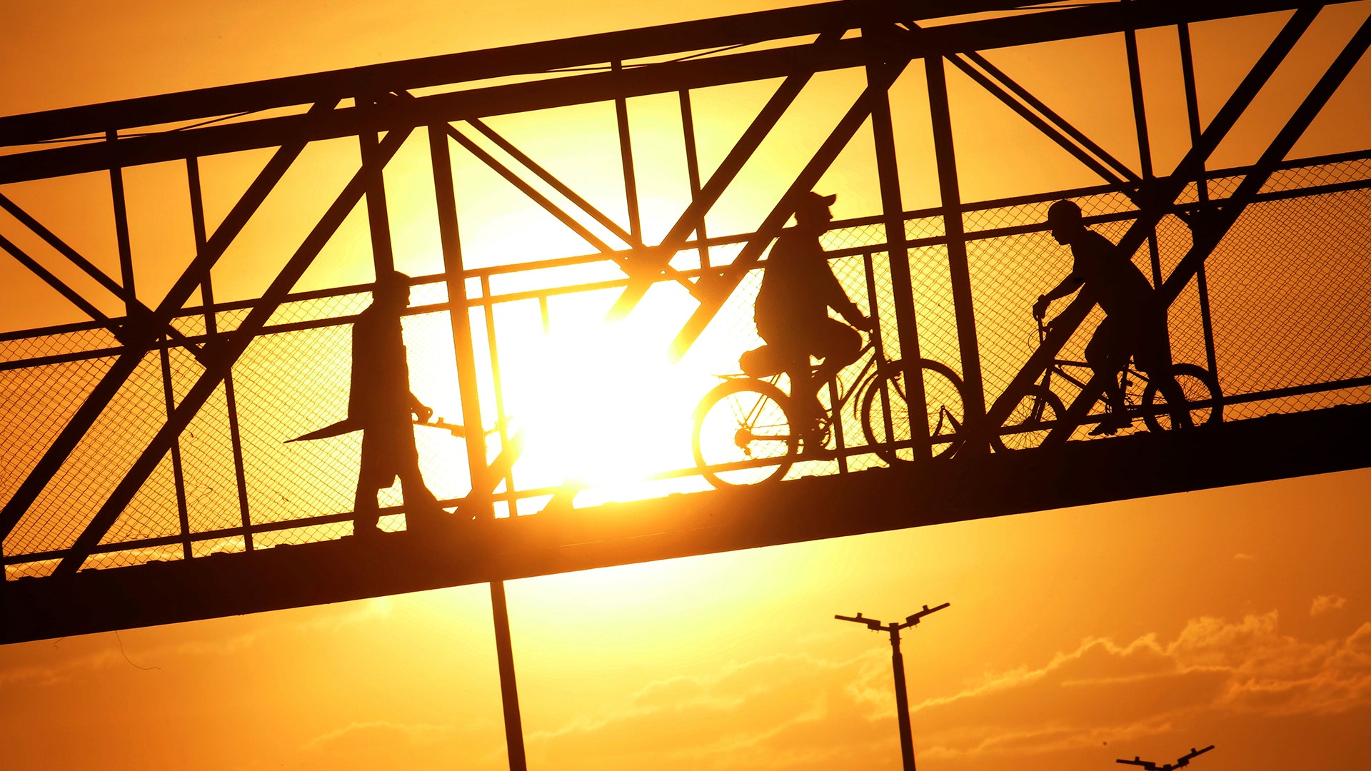 Pedestrians and cyclists use a walkway that crosses over a highway in the Structural neighborhood of Brasilia, Brazil, September 27, 2018