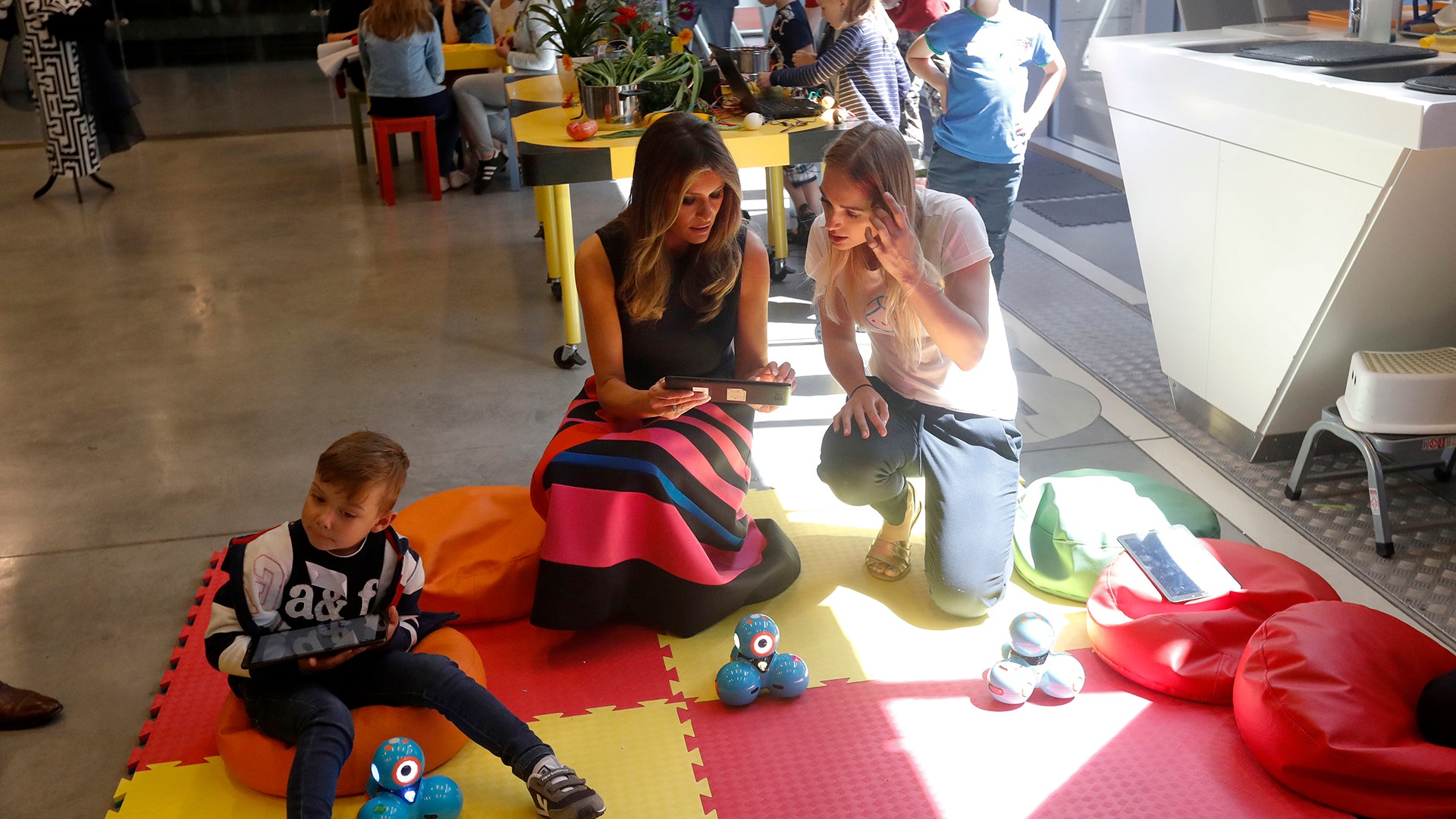 First Lady Melania Trump sits with children during a visit to the Copernicus Science Center, in Warsaw