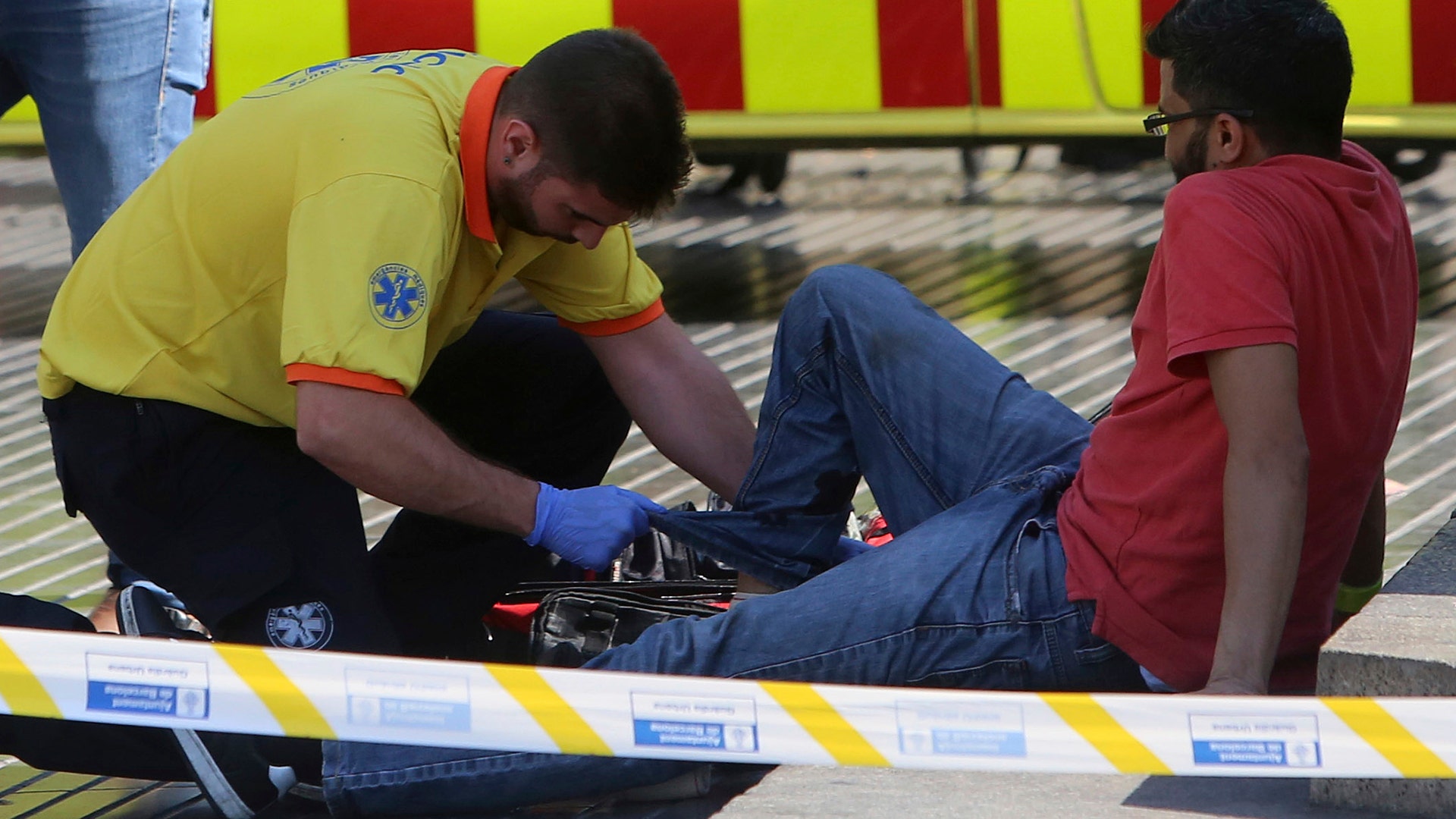 A man is treated after a van crashed into a crowd of residents and tourists on Las Ramblas in Barcelona, August 17